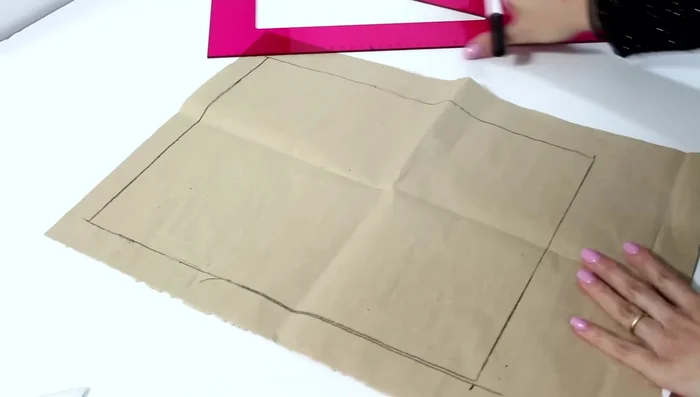 Divide la diferencia entre estas dos medidas por dos. Marca el punto medio de la línea superior y traza una línea vertical hacia abajo.