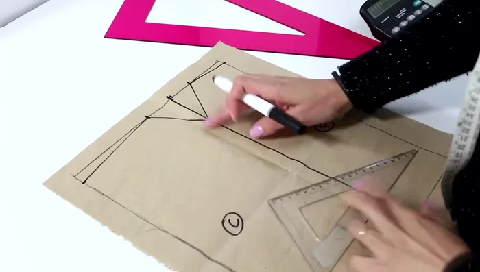 Encuentra el punto medio entre la caída del hombro y el punto marcado previamente. A partir de este punto, sal 2 cm hacia el frente y 1.5 cm hacia atrás. Dibuja una curva suave que conecte estos puntos.