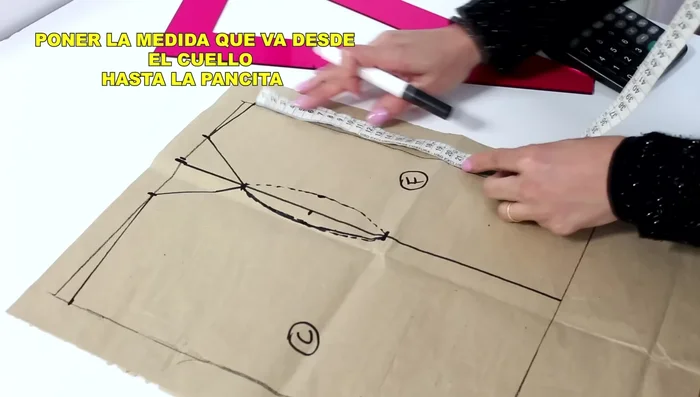 Marca el largo desde el cuello hasta la pancita (medida previamente tomada). Dibuja una curva que conecte este punto con la sisa y el final de la espalda.