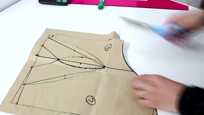 Encuentra el punto medio de la línea inferior del molde delantero. A partir de este punto, baja 0.5 cm a cada lado. Dibuja una curva que conecte estos puntos para crear una pinza.