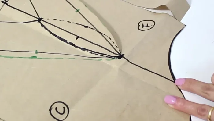 Encuentra el punto medio de la línea inferior del molde delantero. A partir de este punto, baja 0.5 cm a cada lado. Dibuja una curva que conecte estos puntos para crear una pinza.