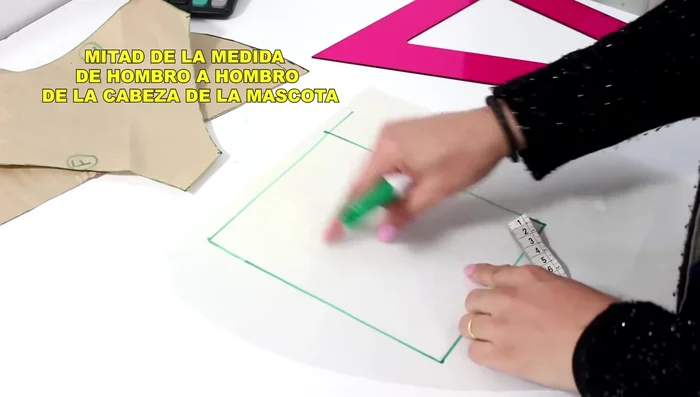 Desde la esquina superior derecha, baja 2 cm. Desde el mismo punto superior, baja 7 cm. Luego, sube 1.5 cm desde ese punto y traza una línea curva para formar la capucha.