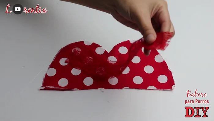 Pegar la blonda o cinta en los dos extremos del babero en diagonal.