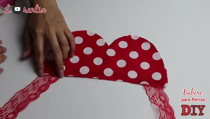 Pegar la blonda o cinta en los dos extremos del babero en diagonal.