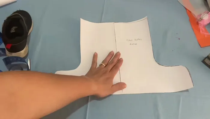 Cortar las piezas: Cortar dos piezas de tela de mezclilla (con 1 cm extra para costuras) y dos de la tela de color, utilizando el patrón.