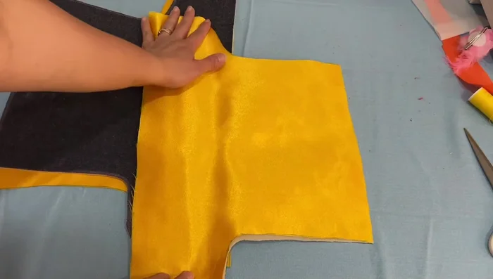 Unir las telas: Coser con puntada zig-zag o recta el contorno de las piezas de mezclilla y de color, uniéndolas.