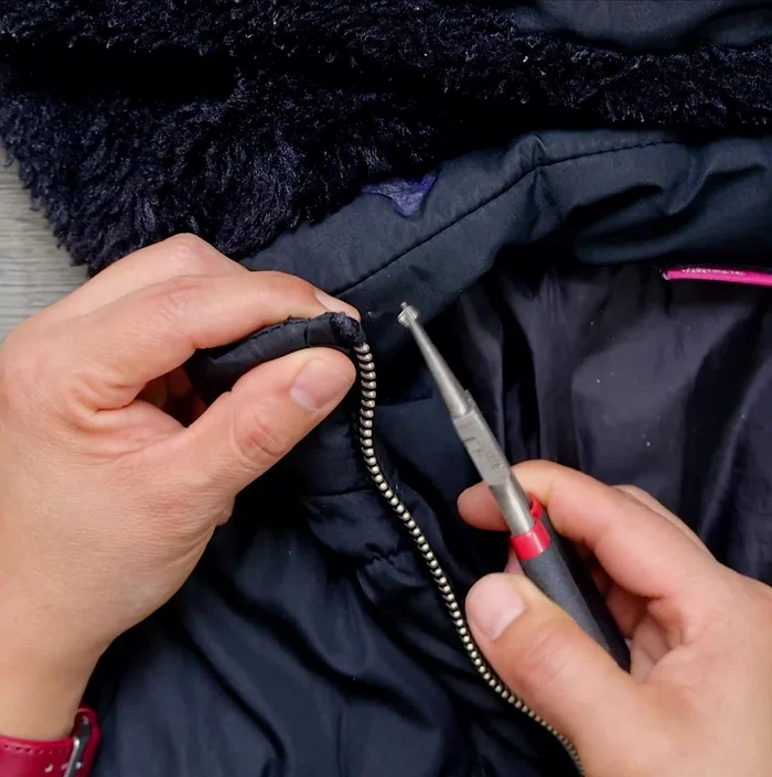 Retira el tope superior de la cremallera de ambos lados.