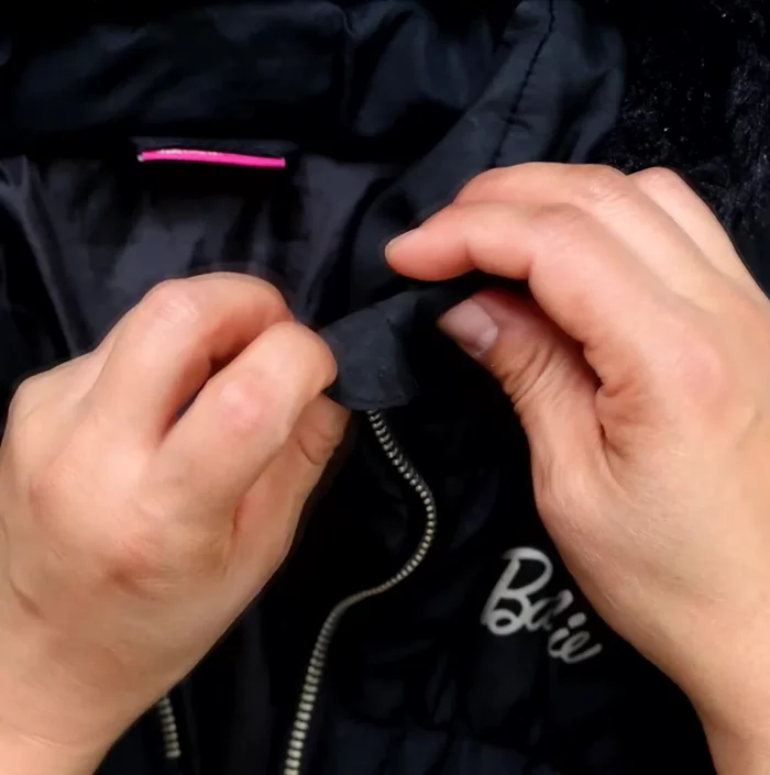 Mueve los topes inferiores hacia abajo, más allá de su posición inicial, para crear espacio y asegurar la cremallera.